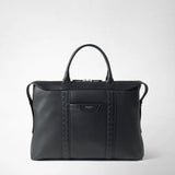 Front view: SOFT BRIEFCASE IN CACHEMIRE LEATHER AND MOSAICO stands with two handles and embossed Mosaico strips against a light background; the logo reads “SERAPIAN MILANO”.