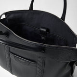 Detail view: SOFT BRIEFCASE IN CACHEMIRE LEATHER AND MOSAICO, open with a black interior compartment, zipper and woven Mosaico leather details; “SERAPIAN” and “MADE IN ITALY” are visible.