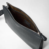 Angled view of the CLUTCH IN CACHEMIRE LEATHER AND MOSAICO, navy blue textured leather with silver zipper and visible lining. SERAPIAN logo readable inside.