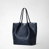 Frontal view: VERTICAL SECRET TOTE BAG IN MOSAICO shows a navy blue leather tote bag with a raised geometric woven pattern and double handles.