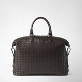 Front view: BRIEFCASE IN MOSAICO is shown with geometrically woven dark brown leather, two rounded handles, and silver-tone hardware against a light background.