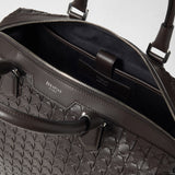 Detail view: BRIEFCASE IN MOSAICO open, showing the black interior compartment, zipper, and dark brown Mosaico leather weave. Visible inscriptions: “SERAPIAN MILANO” and “SERAPIAN MADE IN ITALY”.