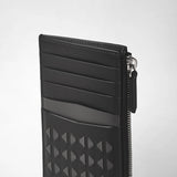Side view: ZIP CARD CASE IN MOSAICO shows a slim black leather card case with five card slots, a textured geometric Mosaico pattern, and a silver zipper.