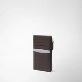 Detail view: ZIP CARD CASE IN MOSAICO is positioned at a slight angle, showing card slots, a side zip pocket, and geometric patterns in ebony brown and ice blue.
