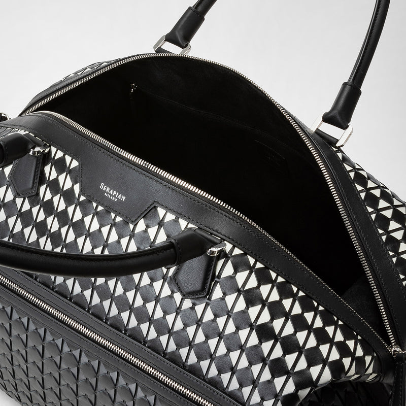 Frontal view of the TRAVEL BAG IN MOSAICO, a spacious travel bag in black-and-white patterned Mosaico Nappa leather featuring an open large main compartment and SERAPIAN MILANO embossing.