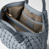 Detail view: MINI SECRET BAG IN RIBBON MOSAICO features ice-blue woven leather, gold-tone zippers, and a taupe lining with a pocket. The label reads “SERAPIAN – MADE IN ITALY”.