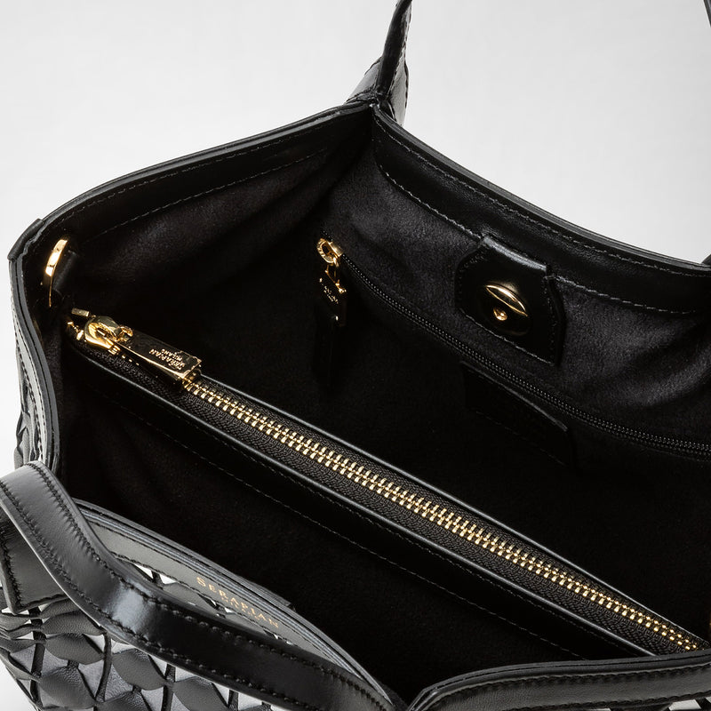 Detail view: MINI SECRET BAG IN MOSAICO shows the interior of a petite black woven leather bag with gold zipper and clasp, highlighting luxurious lining and organization.