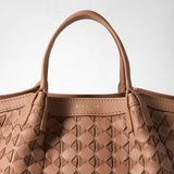 Detail view: MINI SECRET BAG IN MOSAICO shows embossed sandalwood-colored leather handles and an intricately woven mosaic pattern in leather and suede. “SERAPIAN MILANO” is printed on the inner rim.