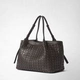 Front view: SMALL SECRET TOTE BAG IN RIBBON MOSAICO stands against a light background; dark brown woven leather, two handles, and side straps. “SERAPIAN MILANO” appears on the front.