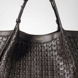 Detail view: SECRET TOTE BAG IN RIBBON MOSAICO features dark brown, three-dimensional woven leather, double shoulder straps, and gold “SERAPIAN MILANO” embossing.