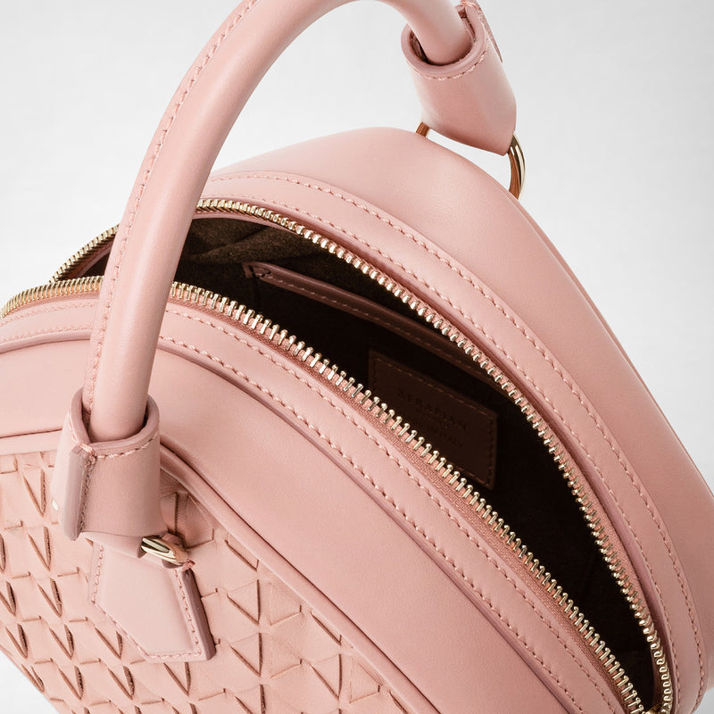Dettaglio ravvicinato dall’alto della PETRA HANDBAG IN MOSAICO in nappa rosa Blush, con manico arrotondato e chiusura a zip dorata, evidenziando la lavorazione intrecciata.