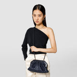 Frontal view: SECRET CLUTCH BAG IN MOSAICO hangs crossbody on a woman, showcasing its unique midnight blue woven pattern and structured, feminine silhouette.