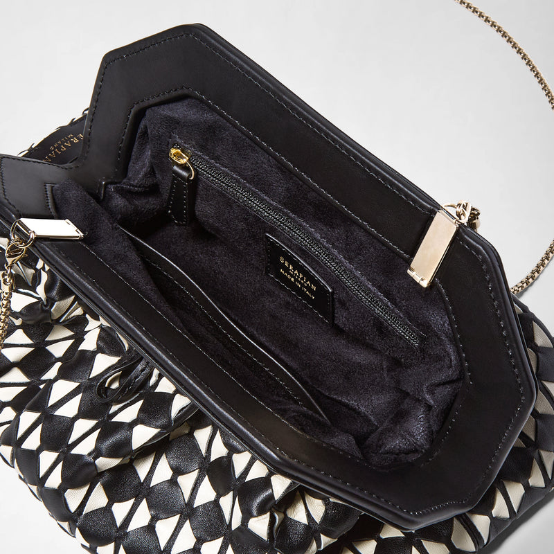 Vista dall&#39;alto: SECRET CLUTCH BAG IN MOSAICO mostra l&#39;interno foderato in tessuto nero con tasca con zip, dettagli metallici dorati e catena, oltre al motivo intrecciato mosaico in pelle nappa bianca e nera.
