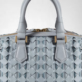 Detail view of the MINI ANI BAG IN RIBBON MOSAICO with a woven ice-blue surface, rounded handles, and gold-tone hardware; “SERAPIAN MILANO” is visible.