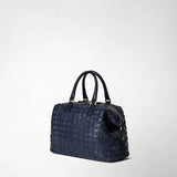 Side view: ANI BAG IN MOSAICO features a structured midnight blue woven leather handbag with two top handles and gold-tone hardware against a plain background.