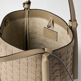 Detail view: MINI BUCKET IN MOSAICO shown open, with Sahara-colored Mosaico leather, a woven exterior, light-colored lining, and strap; “SERAPIAN MILANO MADE IN ITALY” is printed inside.