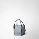 MINI BUCKET IN RIBBON MOSAICO is shown from the front, slightly turned to the side against a light background; ice-blue, three-dimensional woven leather and two slender handles define its shape.