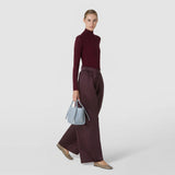 Front view: The MINI BUCKET IN RIBBON MOSAICO hangs from a woman's hand; Arctic blue, geometrically woven leather and short handles stand out against a light background.