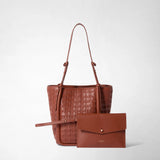 Front view: BUCKET IN MOSAICO bag in brick-red woven leather with long handles and small knots, beside a matching clutch against a light background; inscription: “SERAPIAN MILANO”.