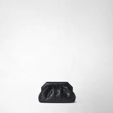Vista frontale: MINI CLUTCH SECRET IN MOSAICO si trova al centro su uno sfondo chiaro da studio; la compatta pochette in pelle nera presenta una vistosa chiusura angolare e un motivo Mosaico intrecciato e lucido.