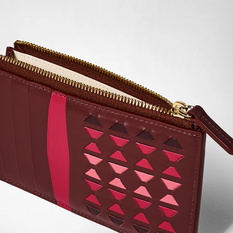 Detail view: ZIP CARD CASE IN MOSAICO made of rosewood leather, features intricate handwoven pink and red geometric patterns, several card slots, and a gold zippered pocket.