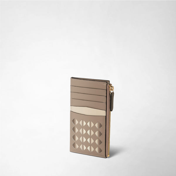 Angled view: ZIP CARD CASE IN MOSAICO in sand-colored leather with mosaic pattern, card slots, and gold zipper, neutral background.