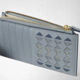 Close-up of the ZIP CARD CASE IN MOSAICO in Arctic Blue leather with a geometric Mosaico pattern and its gold-tone zipper open.