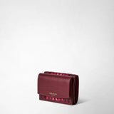 Three-quarter frontal view: MINI TRI-FOLD WALLET IN MOSAICO features a compact rosewood nappa leather wallet with handwoven mosaic pattern and gold lettering 'SERAPIAN MILANO' on the flap.