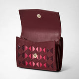 Three-quarter frontal view: MINI TRI-FOLD WALLET IN MOSAICO features a compact, handcrafted rosewood wallet with pink and burgundy Mosaico weaving and a gold snap closure.