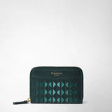 Front view: MINI ZIP WALLET IN MOSAICO, a forest-green wallet with a geometric Mosaico pattern and a gold-colored zipper, against a light background. Visible text: “SERAPIAN MILANO”.