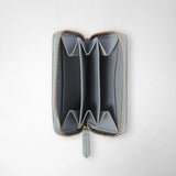 Detail view: MINI ZIP WALLET IN MOSAICO is open, showing an ice-blue interior with several folded compartments and a gold-tone wraparound zipper against a light background.