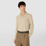 Frontal view: REVERSIBLE BELT IN STEPAN 72 worn by a man dressed in beige shirt and brown pants, showing the black textured belt with a gunmetal buckle and leather insert.
