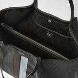 Detail view: SECRET TOTE BAG IN STEPAN shows its dark lining with a zip pocket and slip pocket; the asphalt-gray pattern and ice-blue stripe are visible on the outside. Embossed markings: “SERAPIAN,” “MILANO,” “MADE IN ITALY”.