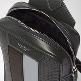 Detail view of the SLING BACKPACK IN STEPAN with the zipper open, dark lining, and asphalt-gray embossed canvas with ice-blue inserts; the “SERAPIAN MILANO” lettering is visible.