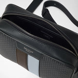 Detail view: CAMERA CROSSBODY BAG IN STEPAN is open, showing the dark interior compartment, zippers, and patterned canvas with leather details in gray and ice blue. Visible lettering: “SERAPIAN MILANO” and “SERAPIAN MADE IN ITALY”.