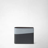 Front view: 6-CARD BILLFOLD WALLET IN STEPAN is shown closed in the studio; dark embossed canvas meets ice-blue leather. Visible lettering: “SERAPIAN MILANO”.