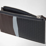 Detail view: ZIP CARD CASE IN STEPAN shows an open, slim case made of patterned dark gray canvas and brown and light blue leather.