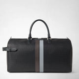 Front view: HOLDALL IN STEPAN stands against a white background, featuring an embossed pattern, black handles, a side strap and brown and light blue leather bands; “SERAPIAN” is written on the central band.