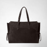 Front view: MAXI MARO BAG IN SUEDE AND MOSAICO appears as a spacious dark brown tote bag with long handles, geometrically woven leather panels, and side tie straps against a light background.