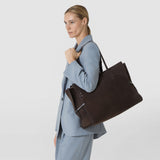 Side view: MAXI MARO BAG IN SUEDE AND MOSAICO hangs over a woman's shoulder; the large dark brown bag features woven Mosaico panels and side leather strips.