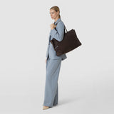 Front view: A woman carries the MAXI MARO BAG IN SUEDE AND MOSAICO over her shoulder. The spacious ebony-brown bag features textured Mosaico details and side leather straps.