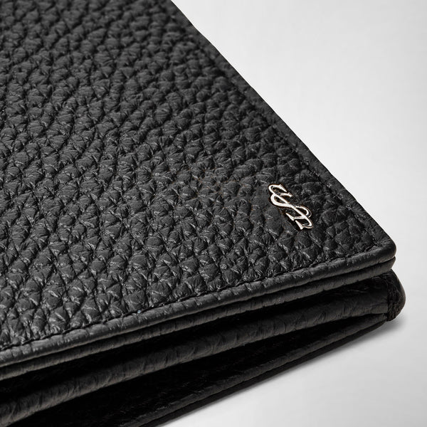 Detail view: COAT WALLET IN CACHEMIRE LEATHER features a close-up of black tumbled calfskin leather texture with a silver logo accent on the corner.